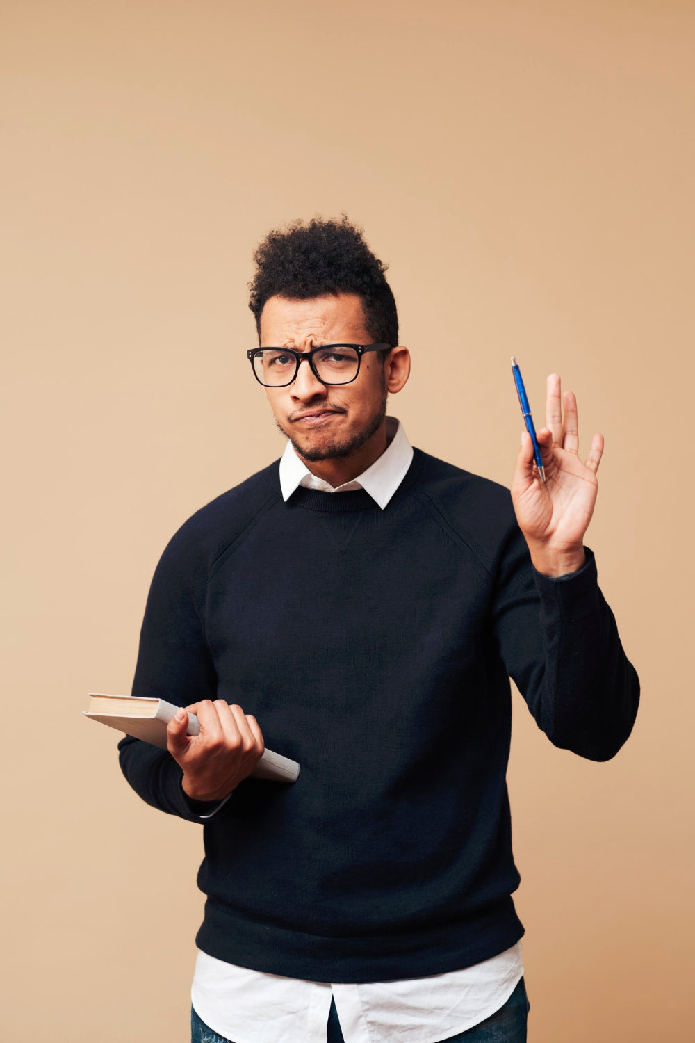Man holding a pen and digital tablet against a beige background