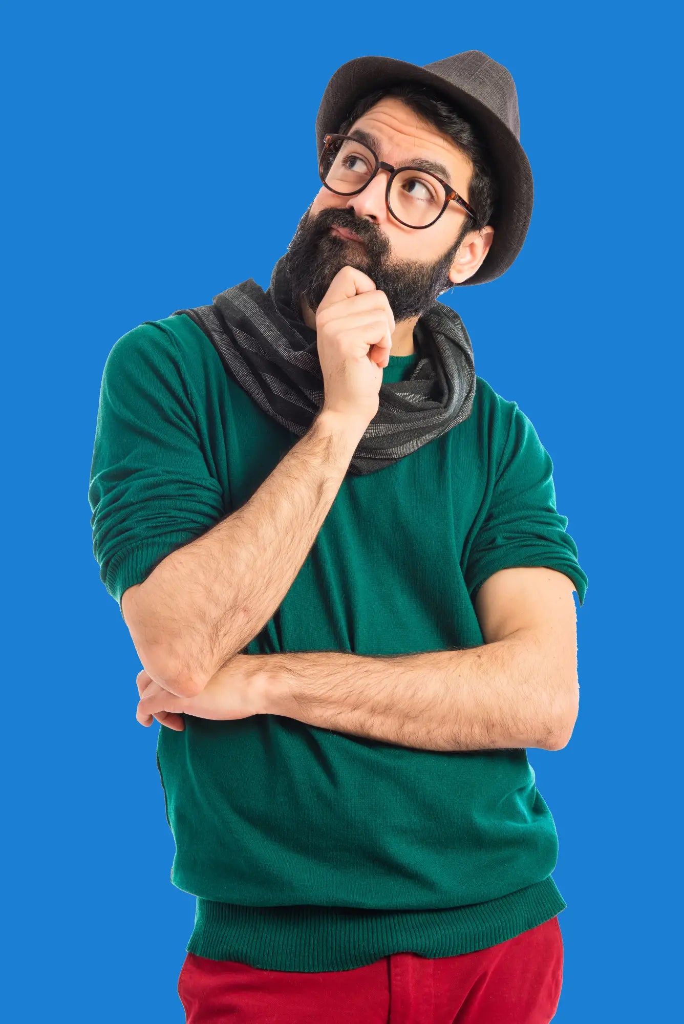Man wearing a green shirt, red pants, black hat, and gray scarf