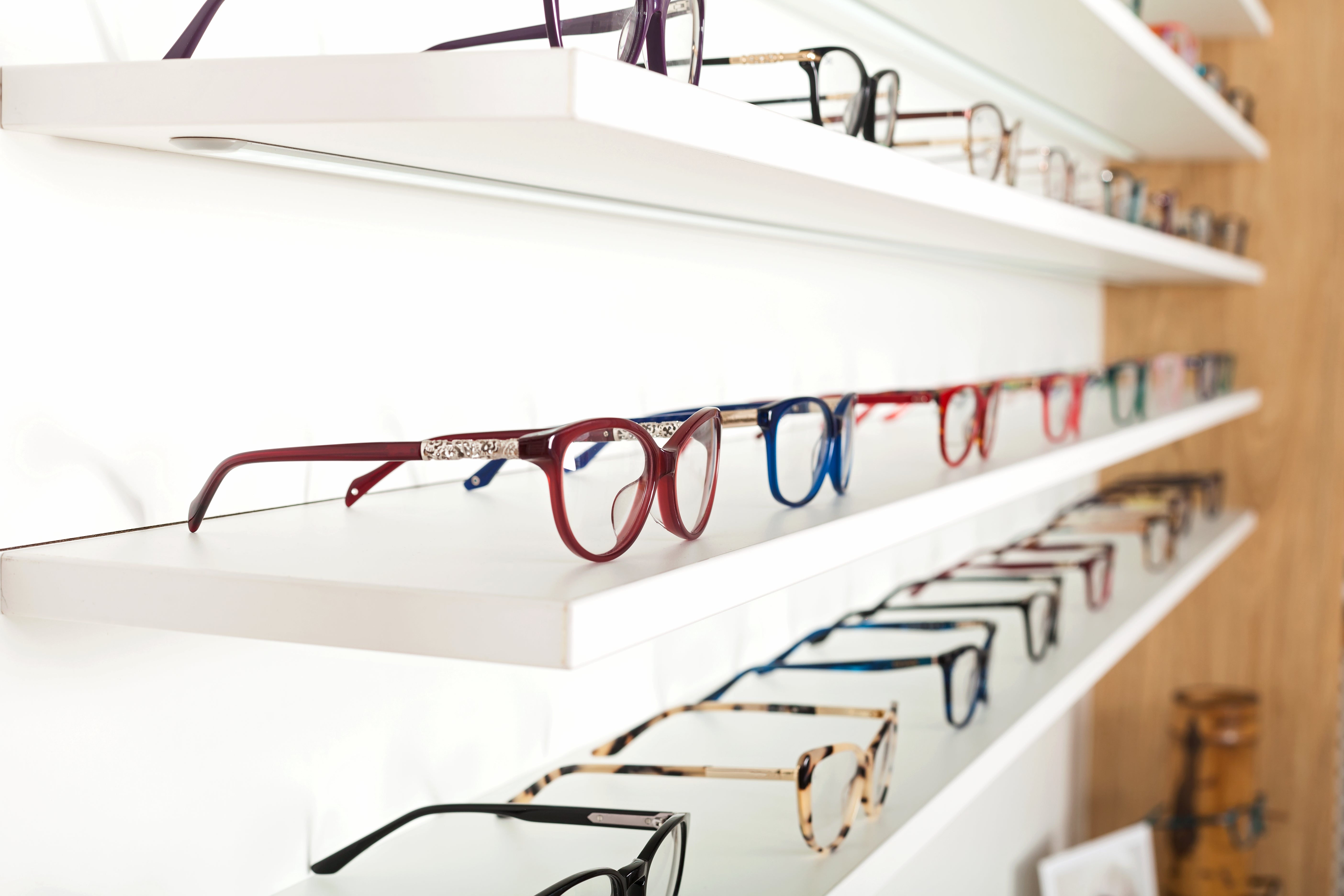 Shelves displaying various eyeglasses in a store setting