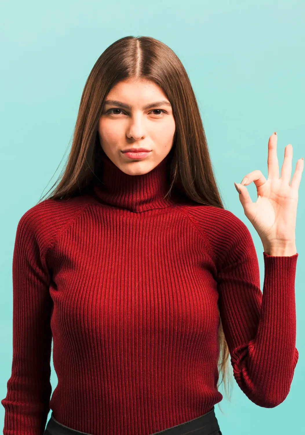 Woman wearing a red turtleneck sweater against a light blue background